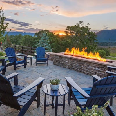 chairs around a fire place looking over a sunset